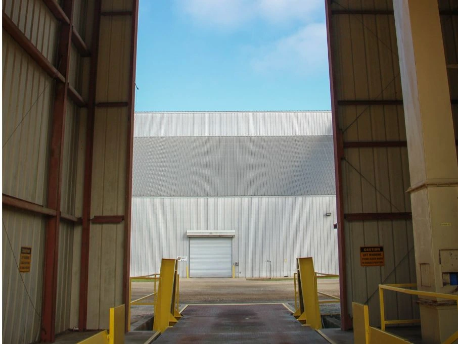 A large warehouse with an open door leading to a spacious interior, showcasing Metal Trees pre-engineered building design