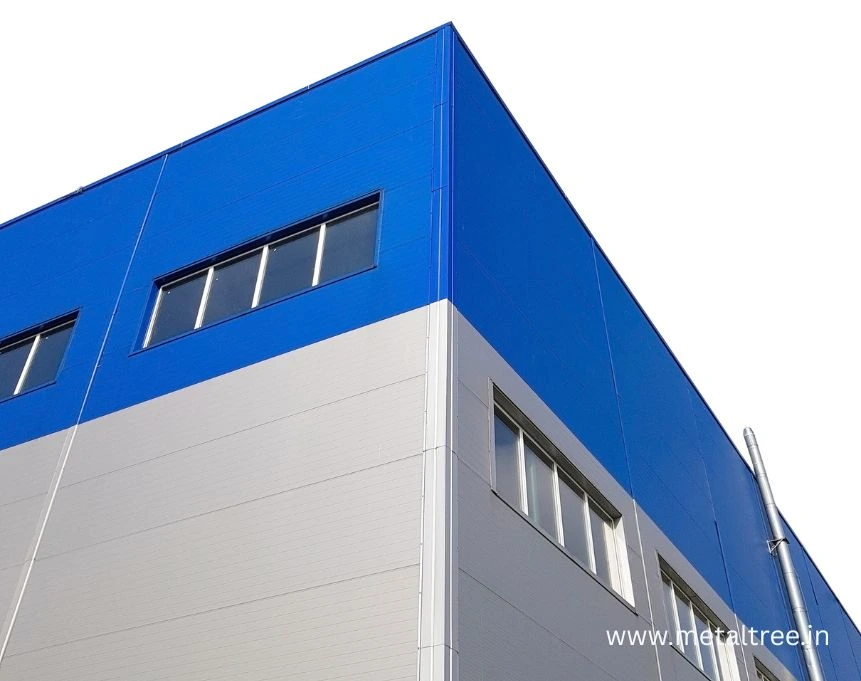 Modular warehouse construction site displaying pre-engineered building assembly process with steel columns and beam installation for industrial applications