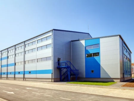 A Blue And White Pre Engineered Building With A Blue Door Showcasing Modern Architectural Design