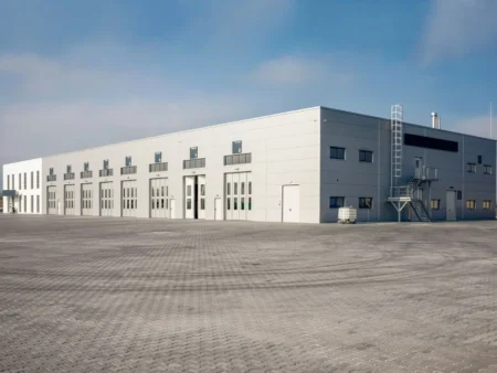 A Large Pre Engineered Industrial Building With A Spacious Parking Lot In Front