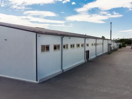 A Large White Building With A Parking Lot Serving As A Prefabricated Porta Cabin Manufacturing Facility