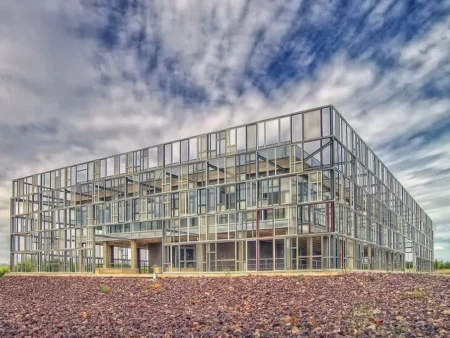 A Pre Engineered Educational Building Featuring A Large Glass Facade Under A Cloudy Sky